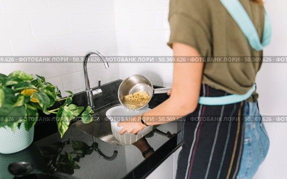 woman straining boiled pasta colander. Стоковое фото, агентство Ingram Publishing / Фотобанк Лори