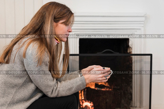 woman sweater drinking tea near fireplace. Стоковое фото, агентство Ingram Publishing / Фотобанк Лори