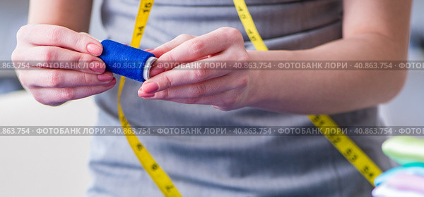 Woman tailor working on a clothing sewing stitching measuring fa. Стоковое фото, фотограф Elnur / Фотобанк Лори