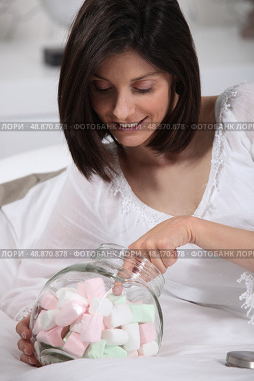 Woman taking marshmallow. Стоковое фото, агентство Ingram Publishing / Фотобанк Лори