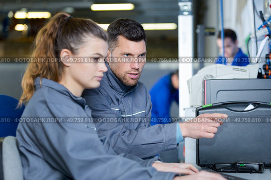 woman training to become a mechanic in auto repair shop. Стоковое фото, агентство Ingram Publishing / Фотобанк Лори