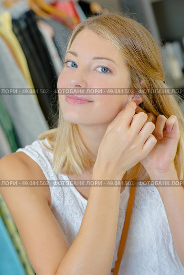 Woman trying on a pair of earrings. Стоковое фото, агентство Ingram Publishing / Фотобанк Лори