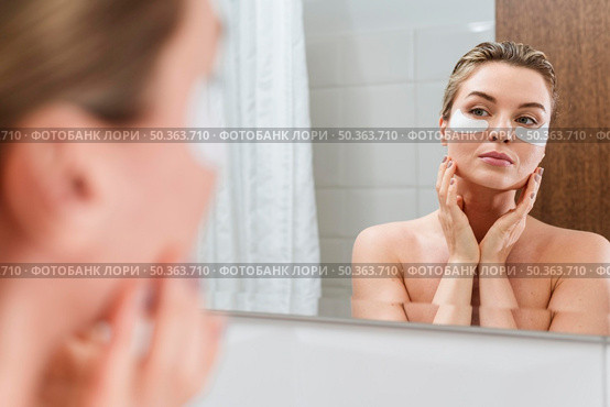 woman using reducing dark circles patches bathroom. Стоковое фото, агентство Ingram Publishing / Фотобанк Лори