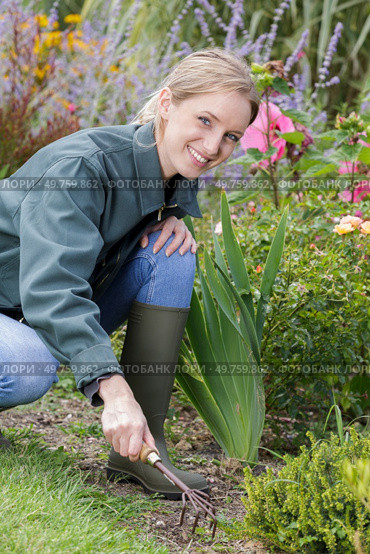 woman using single hand garden rake. Стоковое фото, агентство Ingram Publishing / Фотобанк Лори