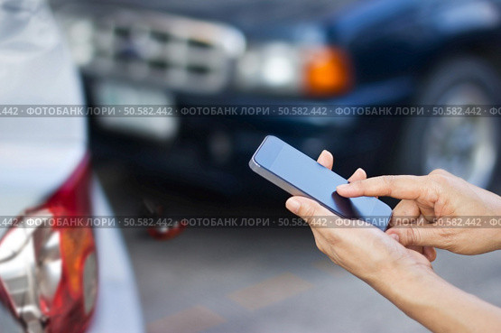 woman using smartphone at roadside after traffic accident, soft focus. Стоковое фото, агентство Ingram Publishing / Фотобанк Лори