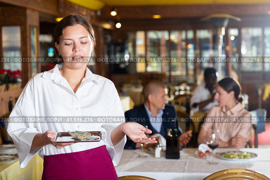 Woman waiter demonstrating her upset with small tip. Стоковое фото, фотограф Яков Филимонов / Фотобанк Лори