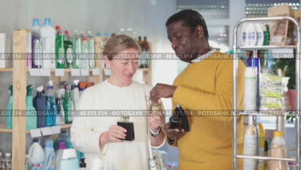 Woman with African man sniffs fragrance of perfume, chooses scent spray with pleasant smell. Стоковое видео, видеограф Яков Филимонов / Фотобанк Лори