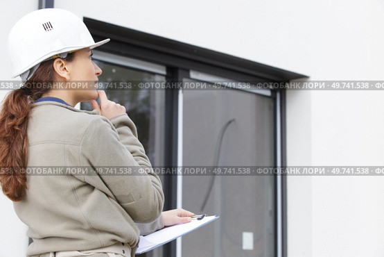 woman with clipboard evaluating the exterior of a property. Стоковое фото, агентство Ingram Publishing / Фотобанк Лори