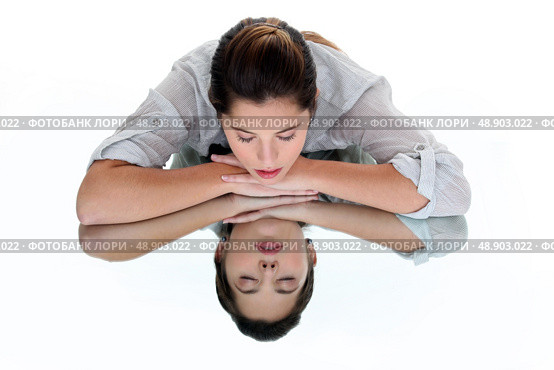 Woman with her eyes closed leaning on a mirrored table. Стоковое фото, агентство Ingram Publishing / Фотобанк Лори
