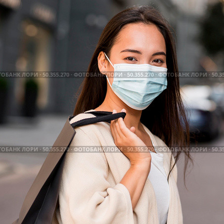 woman with medical mask out sale shopping spree with shopping bag. Стоковое фото, агентство Ingram Publishing / Фотобанк Лори