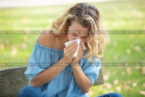 woman with with allergy symptom blowing nose. Стоковое фото, агентство Ingram Publishing / Фотобанк Лори