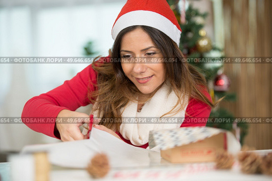 woman wrapping christmas gift box. Стоковое фото, агентство Ingram Publishing / Фотобанк Лори