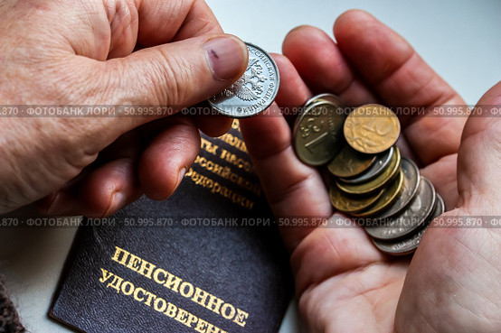 Woman's hands holding russian coins over the pension certificate. Russian translation - Ministry of Social Protection of Population of Russian Federation. Pension Certificate. Стоковое фото, фотограф Denis Vostrikov / Фотобанк Лори