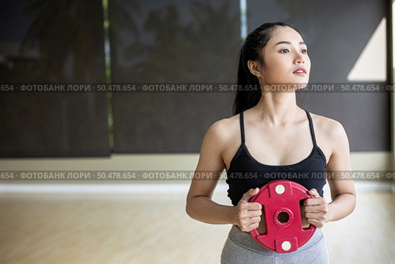 Women exercise with Dumbbell weight plates in the chest. Стоковое фото, агентство Ingram Publishing / Фотобанк Лори