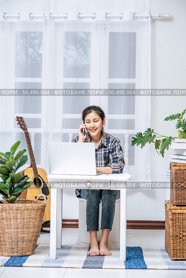 Women sit at the desk and use the phone to coordinate. Стоковое фото, агентство Ingram Publishing / Фотобанк Лори