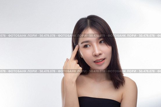 Women wearing black strapless blouses and hands touching the face on the eyebrows. Стоковое фото, агентство Ingram Publishing / Фотобанк Лори