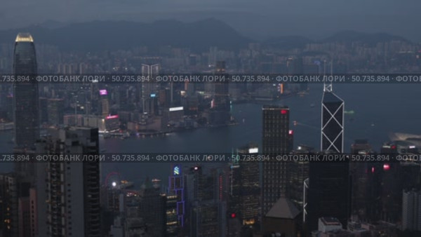 Wonderful aerial view of skyscrapers in downtown and Victoria Harbor in Hong Kong at night. Awesome cityscape. Hong Kong is a popular tourist destination of Asia. Редакционное видео, видеограф Ирина Михайличенко / Фотобанк Лори