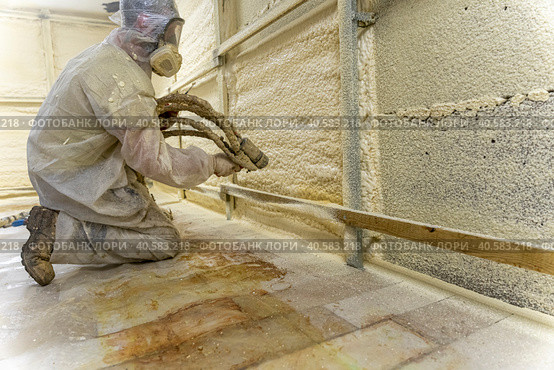 worker in a protective suit insulates the walls with polyurethane foam. Стоковое фото, фотограф Андрей Знаменский / Фотобанк Лори
