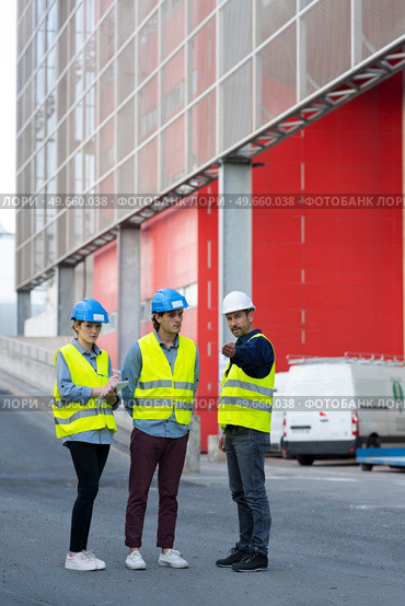 workers in high-visibility vests by loading bays. Стоковое фото, агентство Ingram Publishing / Фотобанк Лори