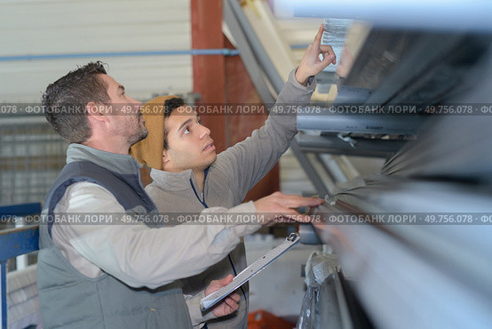 workers with clipboard checking stock of pvc pipes. Стоковое фото, агентство Ingram Publishing / Фотобанк Лори