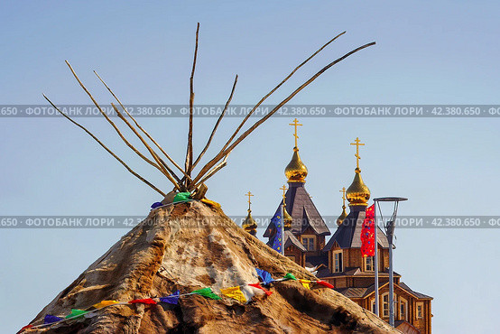 Яранга (традиционный дом чукчей - коренного народа Чукотки) на фоне православного собора. Переносное жилище из оленьих шкур и меха. Анадырь, Чукотка, Россия. Стоковое фото, фотограф Андрей Степанов / Фотобанк Лори