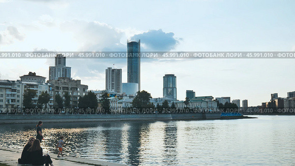 Yekaterinburg, Russia - August 5, 2021: Yekaterinburg skyline mirroring on iset river during twilight, modern architecture blending with waterfront tranquility and urban evening atmosphere. Редакционное фото, фотограф Mikhail Davidovich / Фотобанк Лори