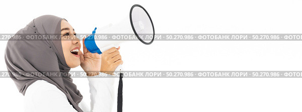 Young adult muslim arab woman wearing hijab communicates shouting loud holding a megaphone using for idea for marketing or sales. Studio shot isolated on white background. Panoramic web banner crop. Стоковое фото, агентство Ingram Publishing / Фотобанк Лори