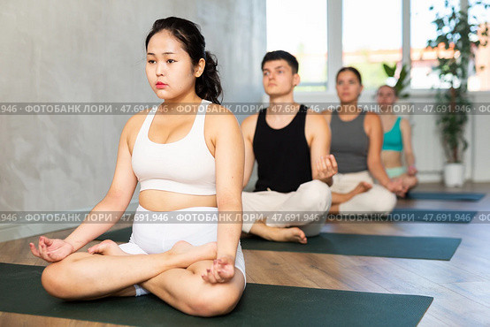 Young Asian lady performs comfortable lotus asana-Padmasana-Siddhasana pose. Стоковое фото, фотограф Яков Филимонов / Фотобанк Лори