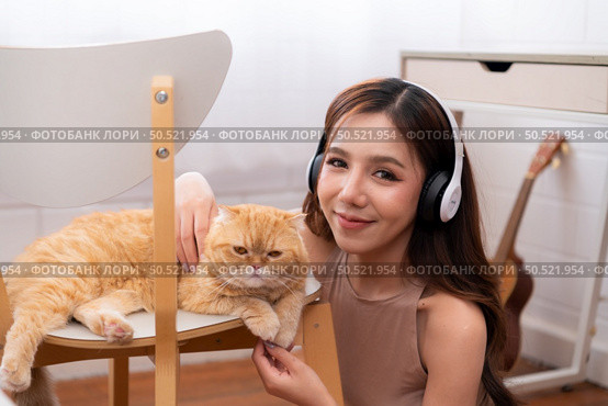 Young asian woman snuggling with a clever Persian cat. with love tenderness. Стоковое фото, агентство Ingram Publishing / Фотобанк Лори