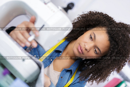 young attractive needlewoman at studio working with sewing machine. Стоковое фото, агентство Ingram Publishing / Фотобанк Лори