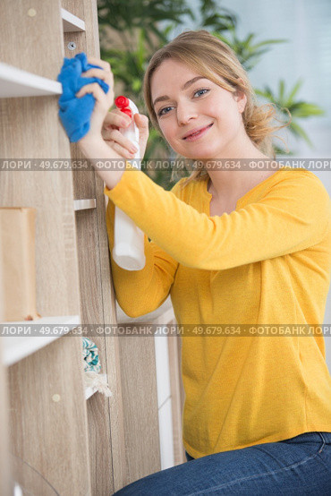 young beautiful woman dusting books. Стоковое фото, агентство Ingram Publishing / Фотобанк Лори