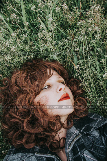 Young beautiful woman resting in a field of flowers. Стоковое фото, агентство Ingram Publishing / Фотобанк Лори