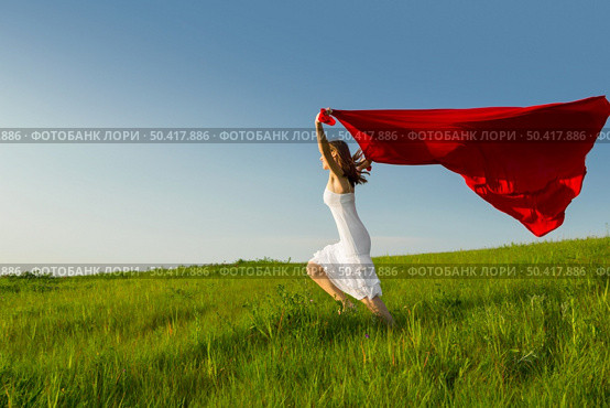 Young beautiful woman running while holding a red tissue. Стоковое фото, агентство Ingram Publishing / Фотобанк Лори