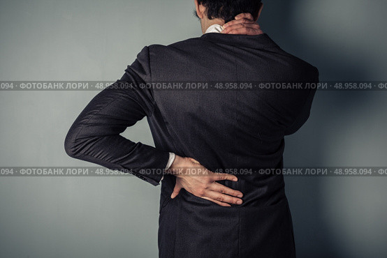 Young businessman with a sore neck and back. Стоковое фото, агентство Ingram Publishing / Фотобанк Лори