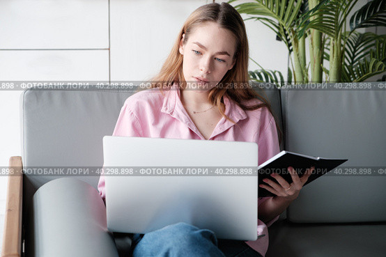 Young caucasian woman using computer, looks at device screen, distance work. Стоковое фото, фотограф Оксана Гильман / Фотобанк Лори