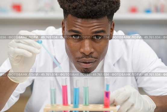 young chemist at work mixing liquids in lab. Стоковое фото, агентство Ingram Publishing / Фотобанк Лори
