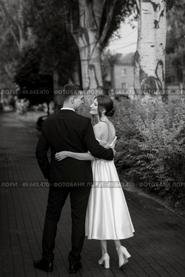 young couple bride and groom in a white short dress walking in the rain. Стоковое фото, агентство Ingram Publishing / Фотобанк Лори