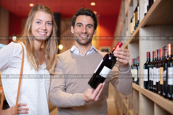 young couple deciding which wine to buy. Стоковое фото, агентство Ingram Publishing / Фотобанк Лори