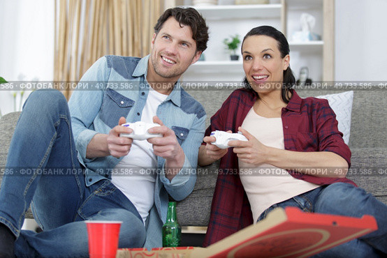 young couple having fun playing videogame at home. Стоковое фото, агентство Ingram Publishing / Фотобанк Лори