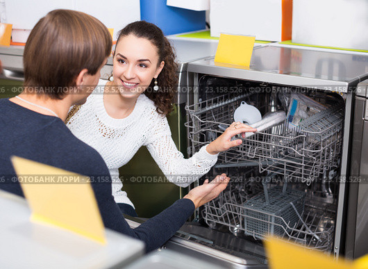 young customers choosing new dish washing machine in appliance store. Стоковое фото, фотограф Яков Филимонов / Фотобанк Лори