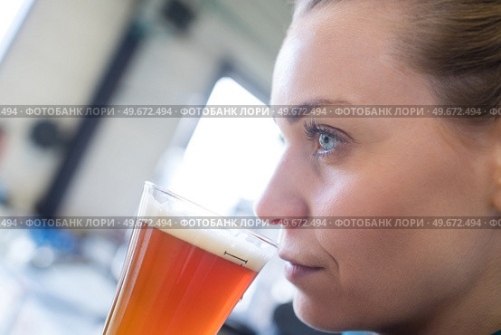 young female bartender tasting draft beer in bar. Стоковое фото, агентство Ingram Publishing / Фотобанк Лори