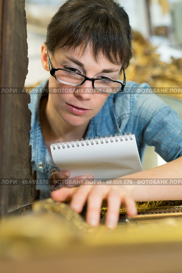 young female checking picture frame detail. Стоковое фото, агентство Ingram Publishing / Фотобанк Лори