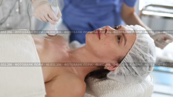 Young female client undergoing anti-aging ultrasonic phonophoresis procedure on decollete at modern aesthetic medicine clinic to tone muscles, improve skin nutrition and tissue turgor. Стоковое видео, видеограф Яков Филимонов / Фотобанк Лори