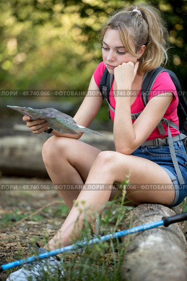 young female hiker sitting while looking at a map. Стоковое фото, агентство Ingram Publishing / Фотобанк Лори