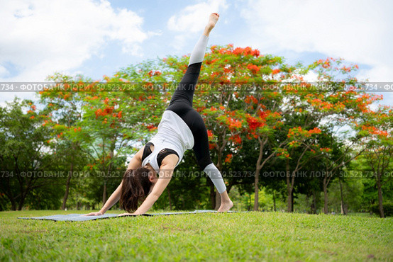 Young female with outdoor activities in the city park, Yoga is her chosen activity. Стоковое фото, агентство Ingram Publishing / Фотобанк Лори