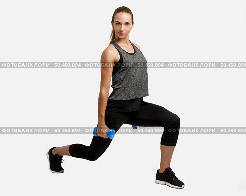 Young fitness woman making exercises with dumbbells. Стоковое фото, агентство Ingram Publishing / Фотобанк Лори