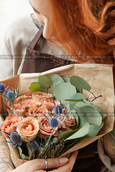 Young girl with red hair holds beautiful bunch of roses living coral colored. Close-up. Conept of celebrating of Mother's Day. Стоковое фото, фотограф Ярослав Данильченко / Фотобанк Лори