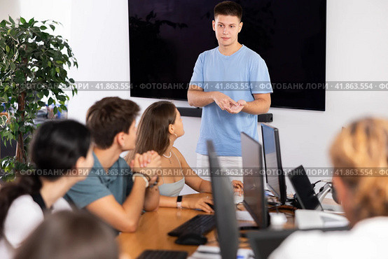 Young guy speaker stands in front of students and talks about use of artificial intelligence. Стоковое фото, фотограф Яков Филимонов / Фотобанк Лори