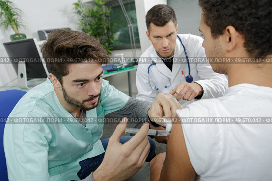 young internist doctor injecting a patient under surveillance. Стоковое фото, агентство Ingram Publishing / Фотобанк Лори
