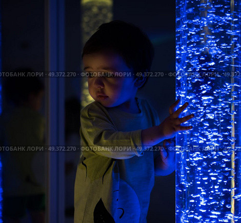 Young kid exploring snoezelen space. Young kid exploring a multi sensory space - snoezelen concept. Стоковое фото, агентство Ingram Publishing / Фотобанк Лори